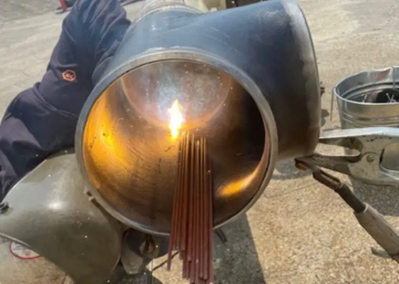 Metal rods inserted into a large cylindrical pipe.