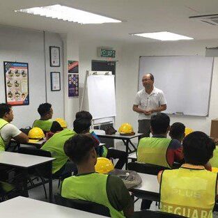 Instructor teaching safety to a group in high-visibility vests.